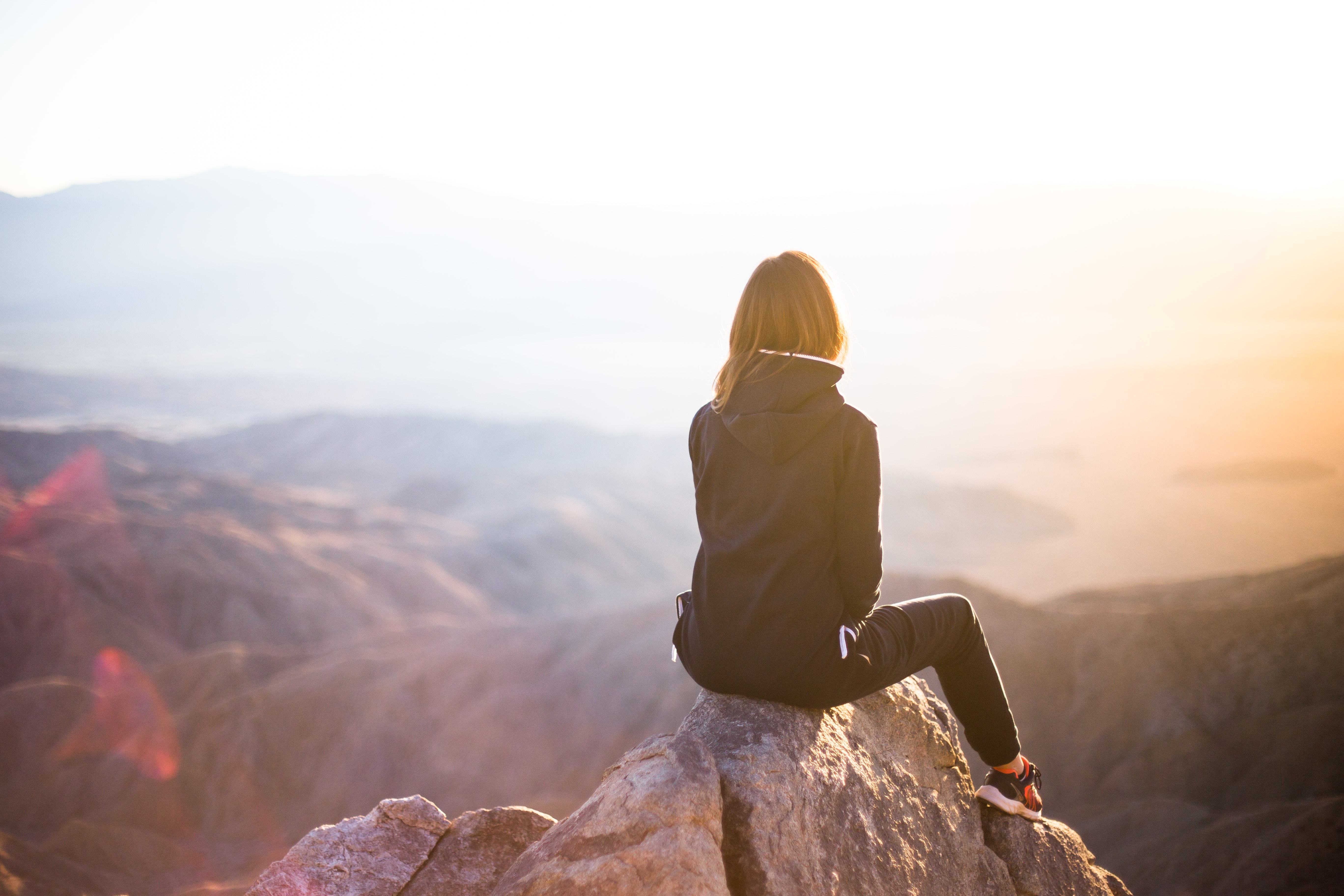 Femme de dos face à un paysage ouvert, symbole d’apaisement et de transformation